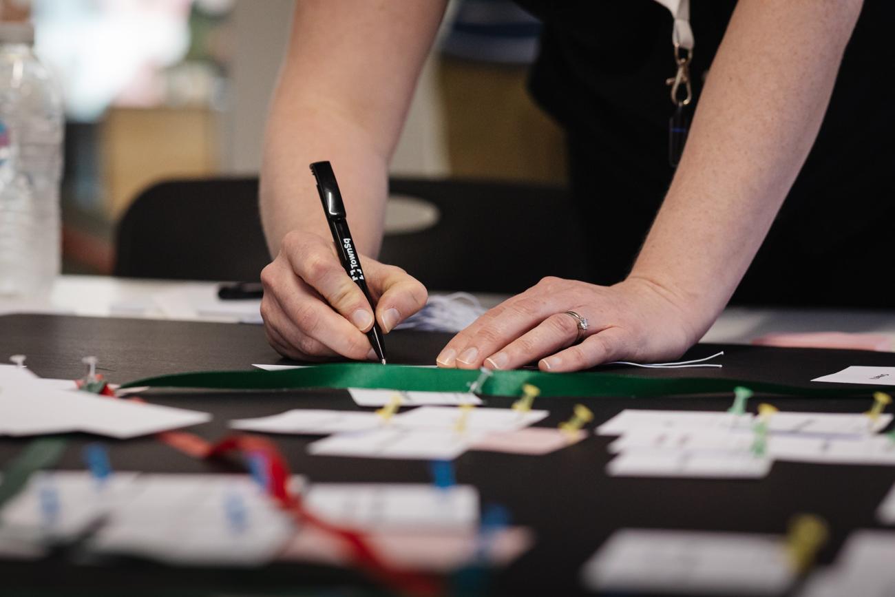A participant writing on a card during an ecosystem mapping exercise