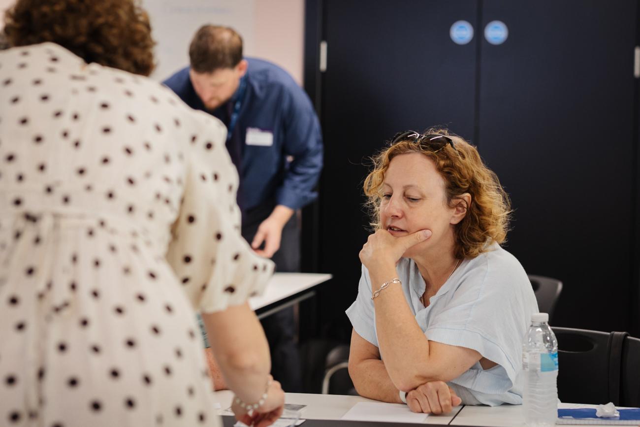 A participant thinking through an idea at a workshop table